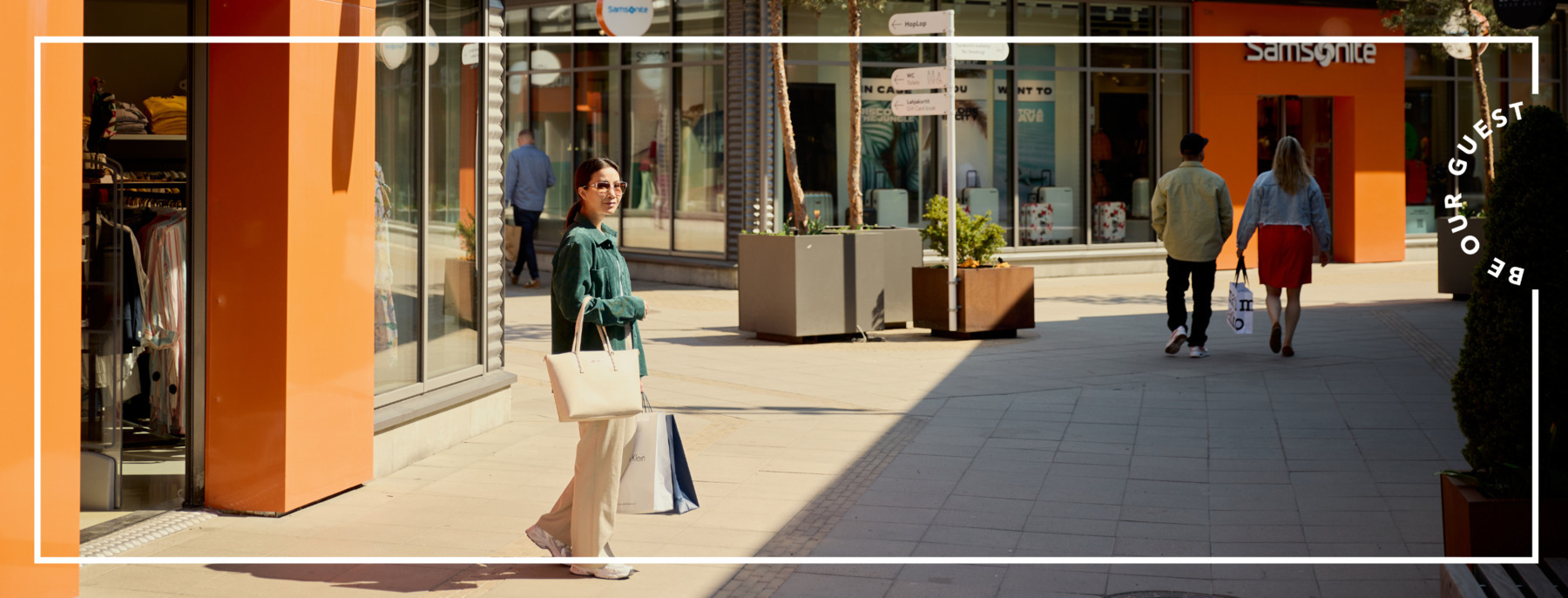 People with shopping bags in  a shopping village. Sunny weather.