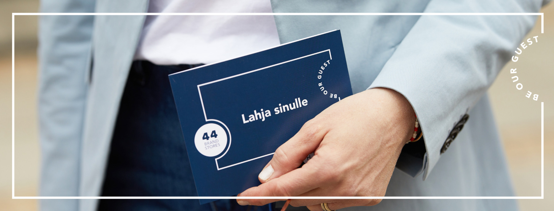 Asiakas pitää kädessä Helsinki Outletin lahjakorttia