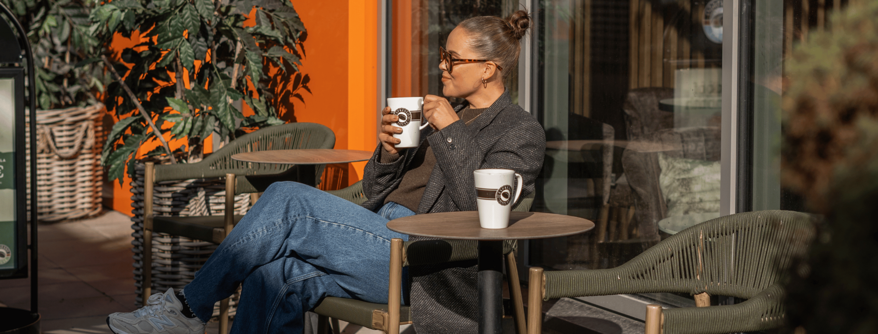A woman having a cup of coffee at Helsinki Outlet Espresso House terrace