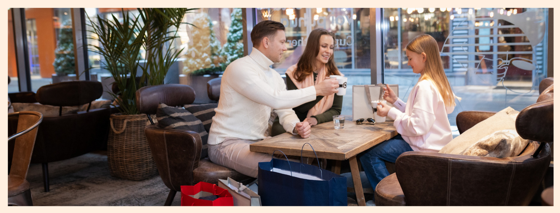 A family is having a coffee break at Espresso House in Helsinki Outlet during their shopping trip