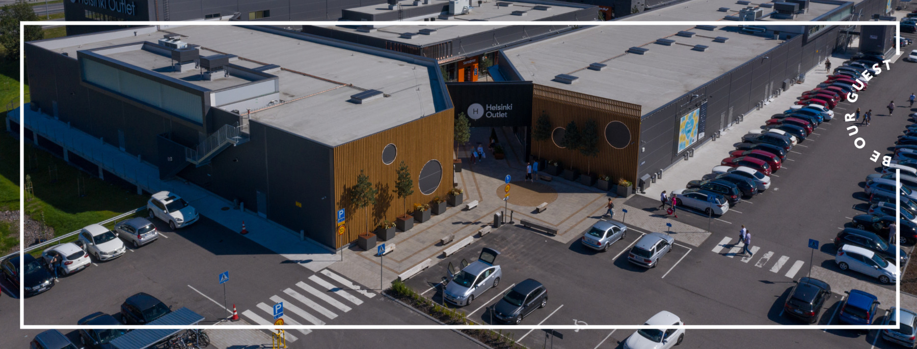 Entrance and parking space of the shopping village photographed from above