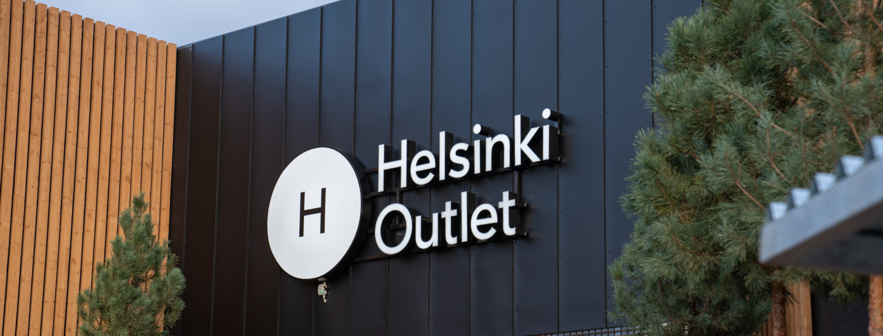 Helsinki Outlet village sign on a building.