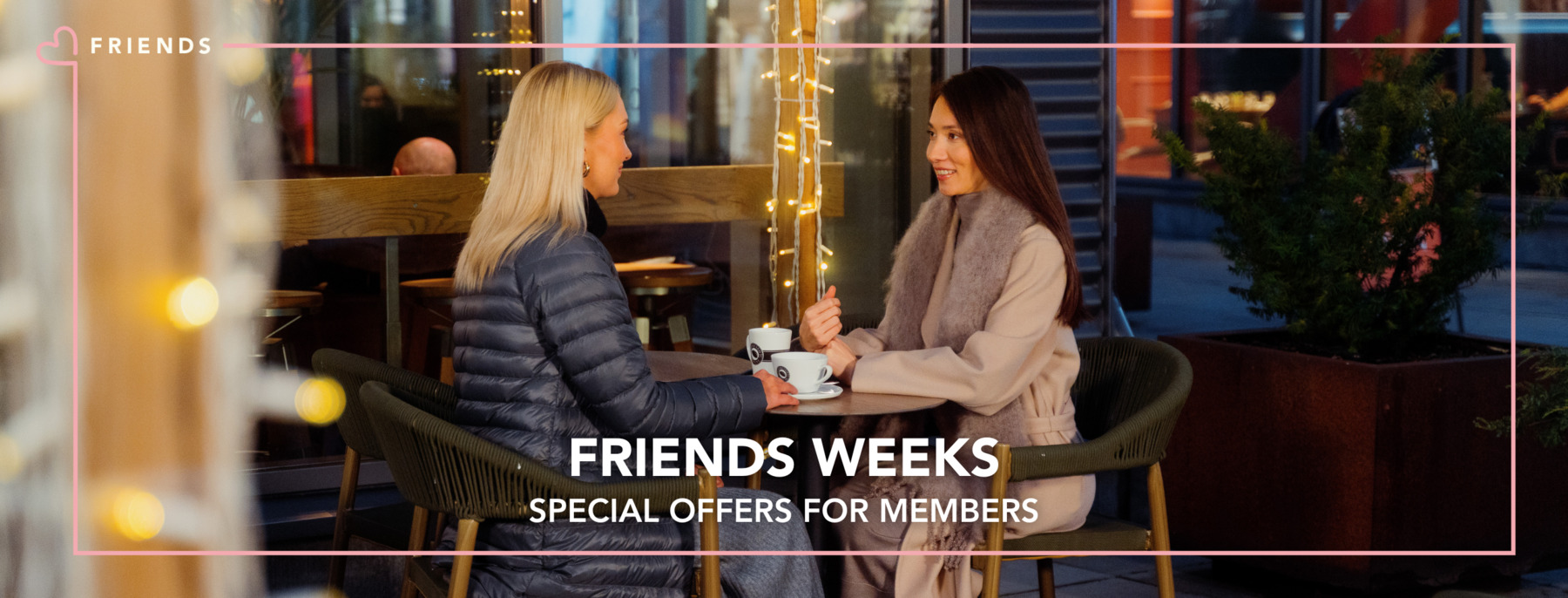 Two women having coffee on the terrace during the cold season
